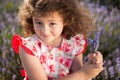 Beautiful happy little girl with bouquet of summer flowers in lavender field Royalty Free Stock Photo