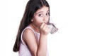 Beautiful happy little girl with long dark hair and dress holding glass of water.