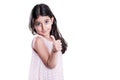 Beautiful happy little girl with long dark hair and dress looking at camera with thumbs up.