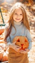 Little girl holding carved jack-o- lantern in hands and smiling