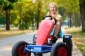 Beautiful happy little girl riding toy car in Royalty Free Stock Photo