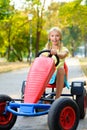 Beautiful happy little girl riding toy car in Royalty Free Stock Photo