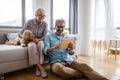 Beautiful happy mature couple is using a digital tablet, talking and smiling at home Royalty Free Stock Photo