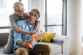 Beautiful happy mature couple is using a digital tablet, talking and smiling at home Royalty Free Stock Photo