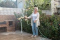 Beautiful happy middle aged woman caring for the summer garden. Royalty Free Stock Photo