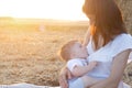 Beautiful happy mother breastfeeding her baby boy outdoor. Royalty Free Stock Photo