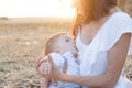 Beautiful happy mother breastfeeding her baby boy outdoor. Royalty Free Stock Photo