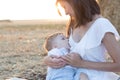 Beautiful happy mother breastfeeding her baby boy outdoor. Royalty Free Stock Photo