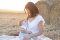 Beautiful happy mother breastfeeding her baby boy outdoor. Royalty Free Stock Photo