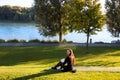 Beautiful happy mother holding and breastfeeding baby in natural park promenade on shore of the river Danube