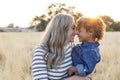 Beautiful Mother holding her adorable curly haired son in the outdoor sunlight Royalty Free Stock Photo