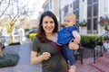 Beautiful happy mother holding her cute baby in peaceful neighborhood Royalty Free Stock Photo