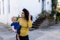 Beautiful happy mother holding her cute baby in peaceful neighborhood Royalty Free Stock Photo