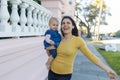 Beautiful happy mother holding her cute baby in peaceful neighborhood Royalty Free Stock Photo