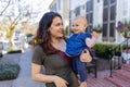 Beautiful happy mother holding her cute baby in peaceful neighborhood Royalty Free Stock Photo