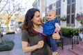 Beautiful happy mother holding her cute baby in peaceful neighborhood Royalty Free Stock Photo