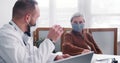 Beautiful happy positive senior Caucasian patient woman listens to doctor giving consultation at light clinic office. Royalty Free Stock Photo