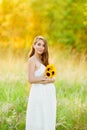 Beautiful happy pregnant girl on the field of daisy flowers in sunset lights