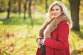 Beautiful happy pregnant woman staying in autumn park touching her belly and enjoying expecting of baby. Royalty Free Stock Photo