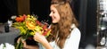 Happy redhead woman with bouquet of autumn flowers in cafe Royalty Free Stock Photo