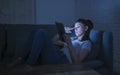 beautiful happy and relaxed latin woman 30s lying on home couch late night using digital device laptop tablet pad watching Royalty Free Stock Photo