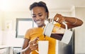 Beautiful, happy and relaxed woman making coffee and pouring hot beverage in cup for morning home kitchen routine. Young Royalty Free Stock Photo