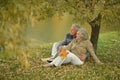 Beautiful happy senior couple relaxing in park with autumn leaves Royalty Free Stock Photo