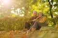 Beautiful happy senior couple relaxing in park with autumn leaves Royalty Free Stock Photo