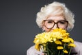 beautiful happy senior lady with yellow flowers, Royalty Free Stock Photo