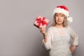 Beautiful happy senior woman in Santa Claus hat showing Xmas gift box present. Christmas or New Year concept Royalty Free Stock Photo