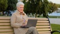 Beautiful happy senior woman using laptop computer outdoor middle aged businesswoman typing on keyboard and smiling Royalty Free Stock Photo