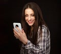 Beautiful happy smiling brunette woman of caucasian in plaid style shirt holding in hand and use mobile cell phone with blank Royalty Free Stock Photo