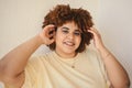 Beautiful happy smiling curvy plus size African black woman afro hair with make up posing in beige t-shirt on white