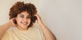 Beautiful happy smiling curvy plus size African black woman afro hair with make up posing in beige t-shirt on white