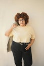 Beautiful happy smiling curvy plus size African black woman afro hair posing beige t-shirt, jeans, stylish glasses on