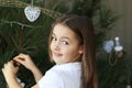 Beautiful happy smiling little girl decorating Christmas tree with white decorations Royalty Free Stock Photo