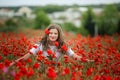 Beautiful happy smiling teen girl portrait with red flowers on head enjoying in poppies field nature background. Makeup Royalty Free Stock Photo