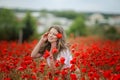 Beautiful happy smiling teen girl portrait with red flowers on head enjoying in poppies field nature background. Makeup Royalty Free Stock Photo