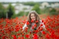 Beautiful happy smiling teen girl portrait with red flowers on head enjoying in poppies field nature background. Makeup Royalty Free Stock Photo