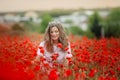 Beautiful happy smiling teen girl portrait with red flowers on head enjoying in poppies field nature background. Makeup Royalty Free Stock Photo