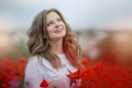 Beautiful happy smiling teen girl portrait with red flowers on head enjoying in poppies field nature background. Makeup Royalty Free Stock Photo