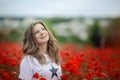 Beautiful happy smiling teen girl portrait with red flowers on head enjoying in poppies field nature background. Makeup Royalty Free Stock Photo