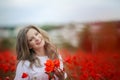 Beautiful happy smiling teen girl portrait with red flowers on head enjoying in poppies field nature background. Makeup Royalty Free Stock Photo