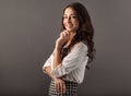 Beautiful happy smiling woman with long brown curly healthy hair style with hand under face looking up and dreaming about in white Royalty Free Stock Photo