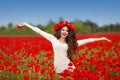 Beautiful happy smiling woman open arms in red poppy field nature background. Attractive brunette young girl model with curly Royalty Free Stock Photo