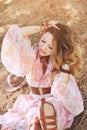 Beautiful happy smiling woman portrait sitting on a hay in autumn forest, Royalty Free Stock Photo