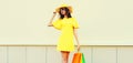 Beautiful happy smiling woman with shopping bags wearing yellow dress and summer straw hat in the city Royalty Free Stock Photo