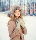 Beautiful happy smiling woman wearing a coat and hat over snow in winter Royalty Free Stock Photo