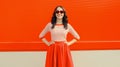 Beautiful happy smiling young brunette woman posing in red heart shaped sunglasses, skirt in city Royalty Free Stock Photo