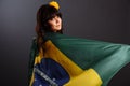 Beautiful happy smiling young woman holding Brazil flag wearing soccer top Royalty Free Stock Photo